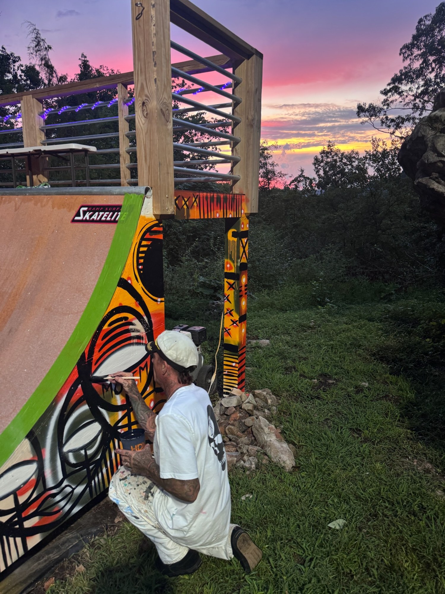 Kris painting the ramp at sunset under a pink sky