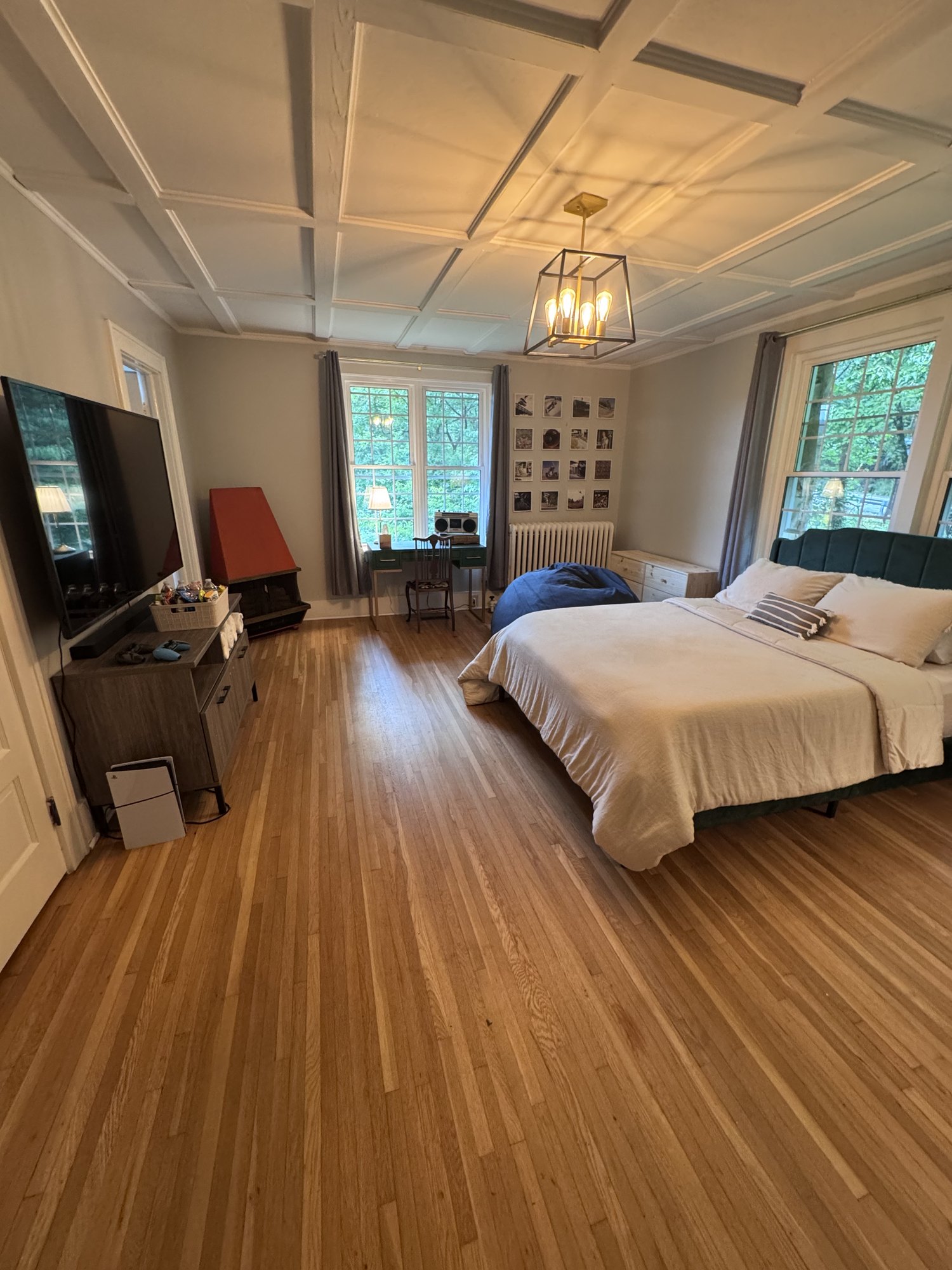 Bedroom with a teal bed, TV, and coffered ceiling